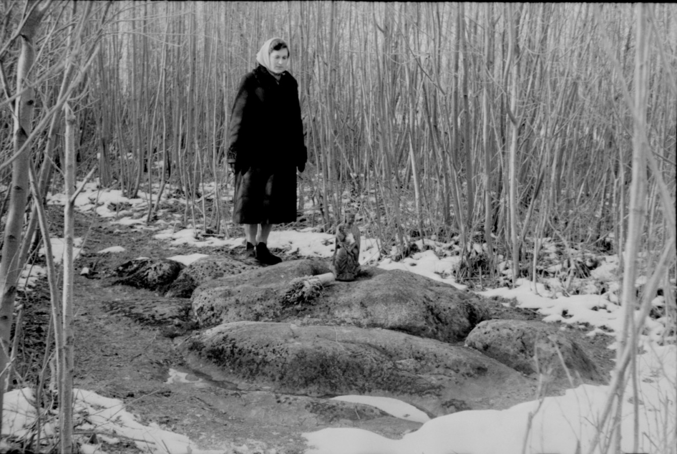 Moteris prie Zigmantiškių akmens su Marijos pėda 